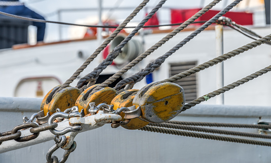 View of group of wooden pulleys and ropes in a sailboat.