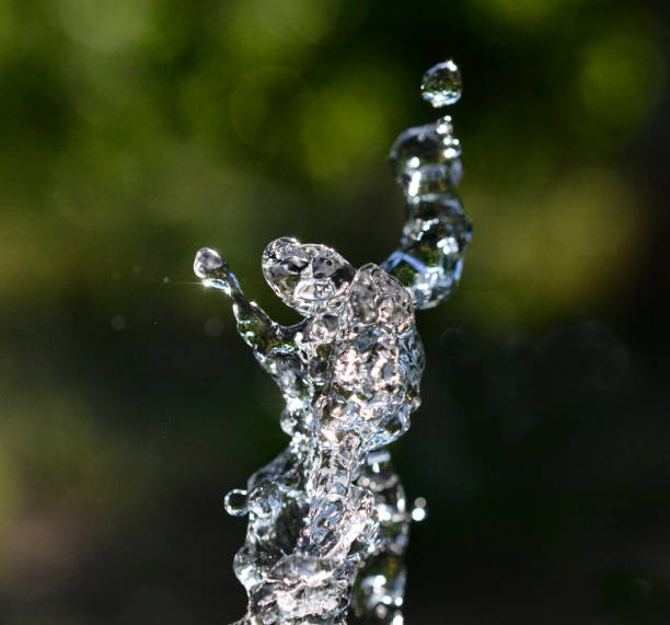 istock Waterdrops levitate on dark green background. shape of dancer 1398858712