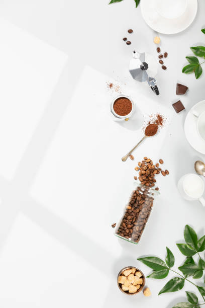 istock Coffee composition on light grey background, window shadow and green branches, flat lay, top view 1398859765
