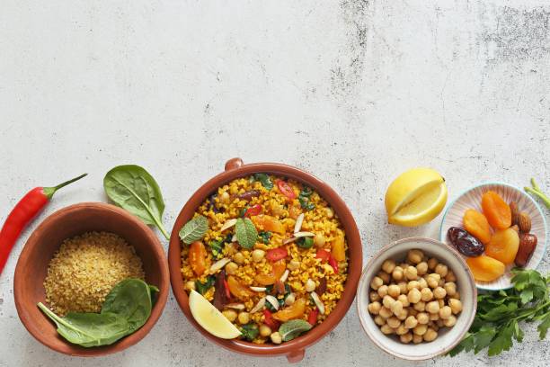 Vegan Moroccan Bulgur with Chick Peas, spinach, dried apricots and date fruit. Traditional African Tajine dish. Flat layot