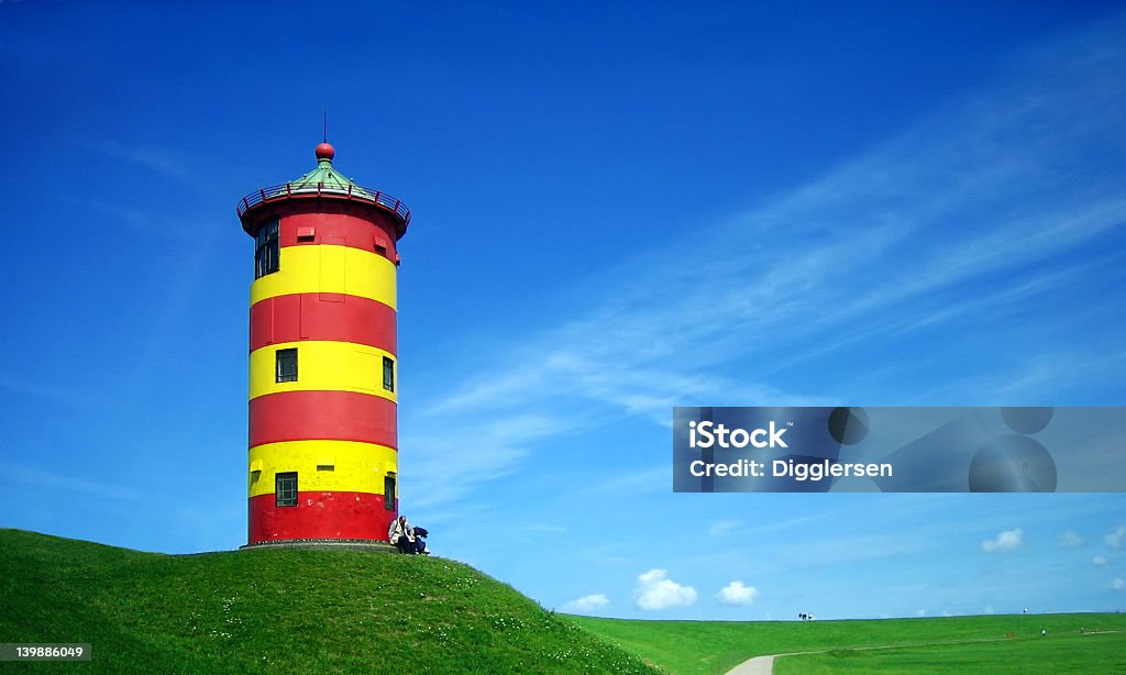 Lighthouse in summer Red and yellow painted lighthouse on a beautiful summer day in Ostfriesland, North of Germany. Lighthouse Stock Photo