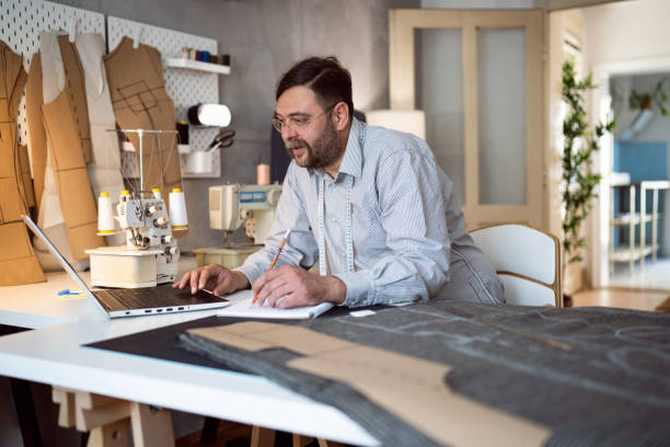 istock Mid-adult Caucasian male tailor sketching new designs, while working at his studio 1398861059