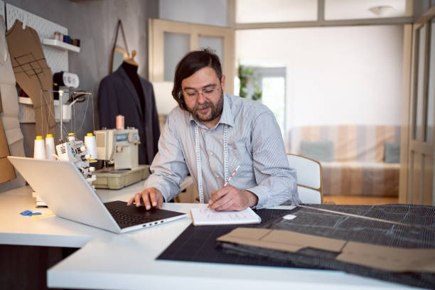 istock Caucasian male tailor sketching new designs, while working at his studio 1398861061