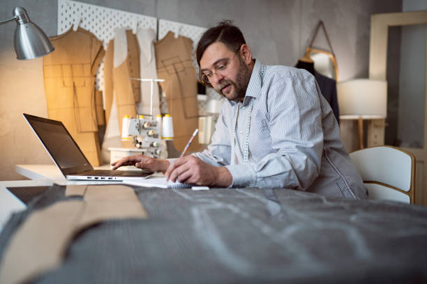 istock Caucasian male tailor sketching new designs, while working at his studio 1398861147