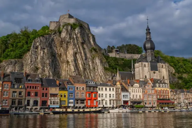 Colorful Dinant town view with its citadel and church by sunset, Belgium