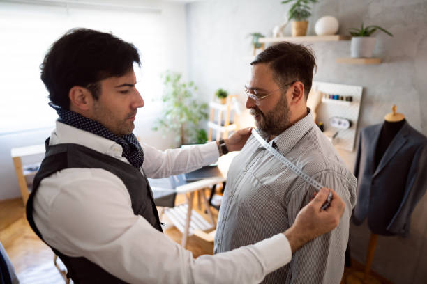 istock Male tailor taking measures of the male client 1398862930
