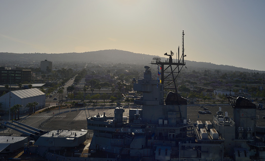 A high angle view of the USS Iowa on display in San Pedro, CA as the sun rises over the hills in the background