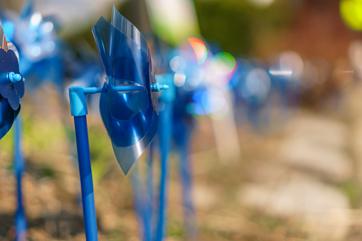 Close up of bright blue pinwheels which are a symbol commemorating National Child Abuse Prevention Month each April.