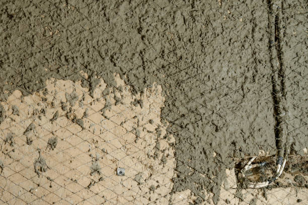 istock The master throws a solution of liquid concrete on the wall, the first layer of plaster on the wall. 1398863156