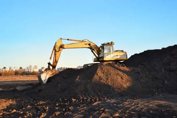 Excavator on earthmoving during construction. Loader at open pit mining. Excavator digs gravel in quarry. Heavy construction equipment on excavation. Earth mover ar construction site. Open-pit mine.