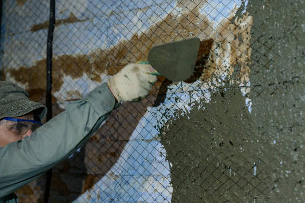 istock The master throws a solution of liquid concrete on the wall, the first layer of plaster on the wall. 1398863380