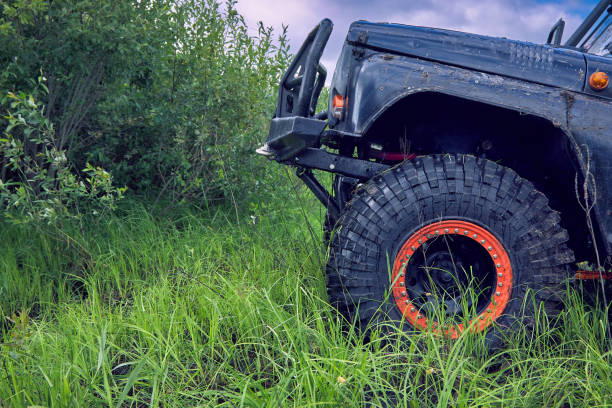 une voiture tout-terrain 4x4 surmonte un obstacle en montant la colline - sports utility vehicle 4x4 car mud photos et images de collection