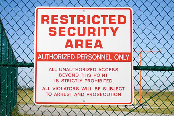 Never sharpened; restricted security sign posted on fence of Cleveland Hopkins airport.
