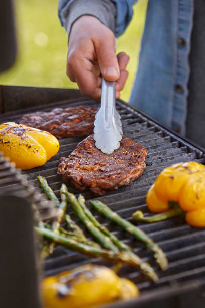 grilling rib eye steaks on the bbq - red meat meat dish grilled rare imagens e fotografias de stock