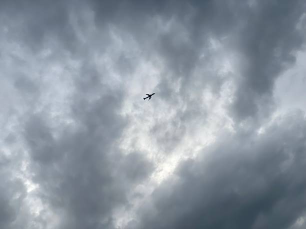 istock Silhouette of an airplane against a cloudy sky 1398865894