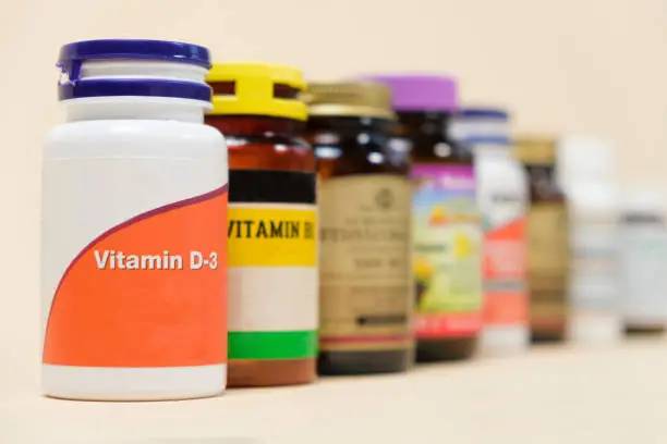 Vitamin D3 and other vitamins on a beige background. Dietary supplements for people.