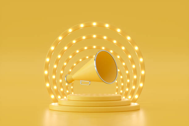 istock Megaphone on podium with glowing spot lights yellow background 1398866452