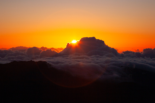 At 10,000 feet, the sun rise above the sea of clouds, at the top of Mount Haleakala.