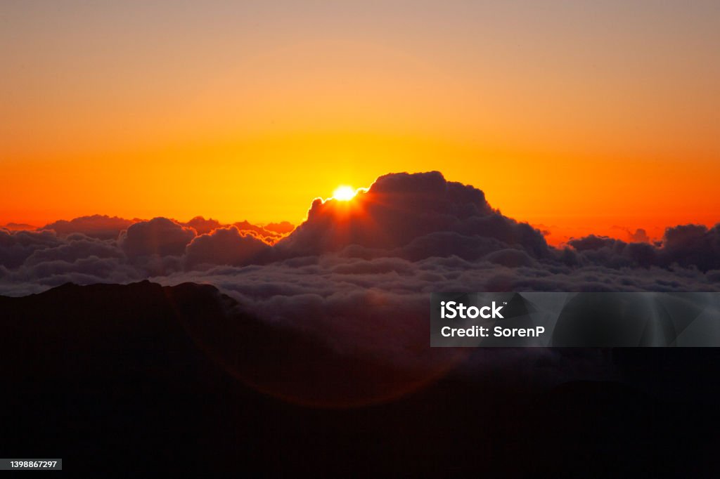 Haleakala sunrise At 10,000 feet, the sun rise above the sea of clouds, at the top of Mount Haleakala. Haleakala National Park Stock Photo