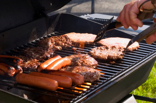 Hotdogs and hamburgers on the grill at a summer cookout. Memorial Day, Fourth of July. Graduation parties.