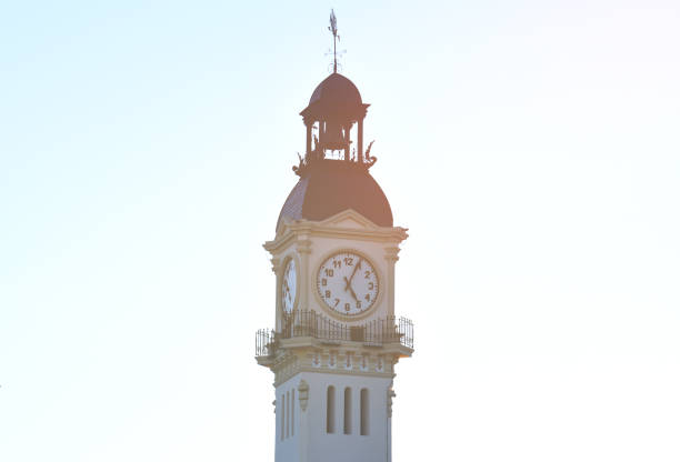 istock Clock tower building. Large clock tower with hour hands that shows the time of day and night. Clock tower on blue sky 1398869930