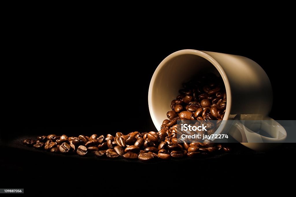 spilled beans coffee beans spilled out of coffee cup Black Color Stock Photo
