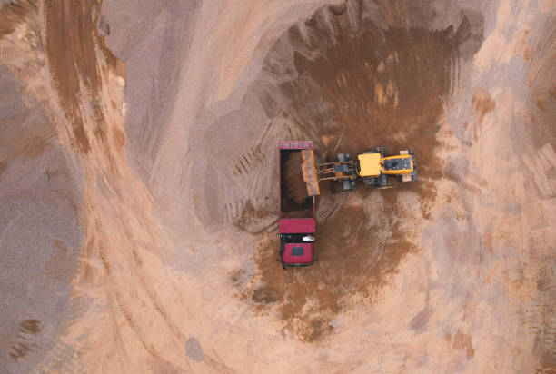 istock Wheel loader load crushed stone in dump truck in open pit. Heavy machinery on developing opencast. 1398871731