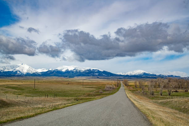 istock Montana rural highway headed toward snow capped Mountains 1398873511