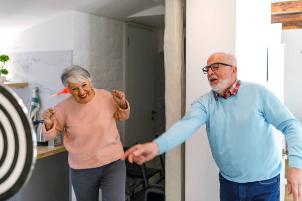 istock Senior couple playing darts together. 1398874749