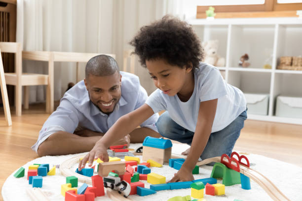 istock Cute boy play wooden railroad and bricks with loving daddy 1398877781