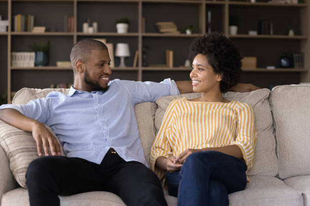 istock African couple having conversation seated on sofa at home 1398877838