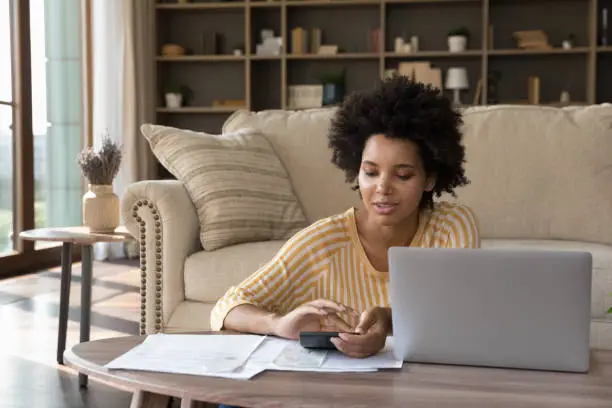 Photo of Beautiful 30s African woman managing personal budget makes e-payment