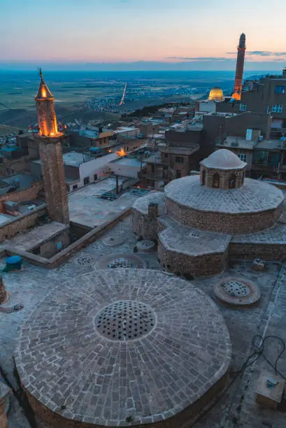gün batımında Mardin şehir manzarası. mavi saatte ışıkları yanan minarelerin görüntüsü. türk hamamı çatısı üstten görüntülenmiştir. full frame makine ile çekilmiştir.