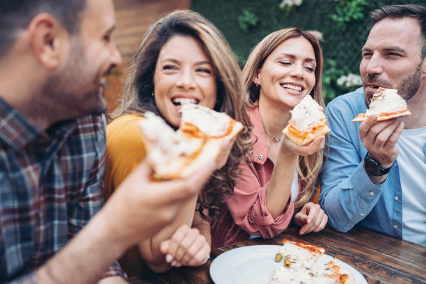 istock Happy friends eating pizza 1398879697