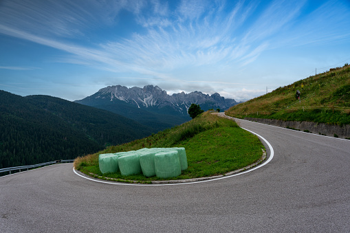 curvy, rural mountain road in italian alps looking at beautiful mountain range