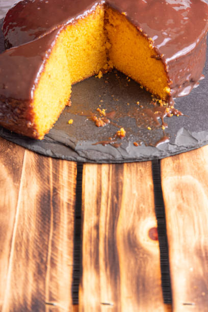 istock Sliced carrot cake, covered in chocolate on stone surface over rustic wood, selective focus. 1398879886