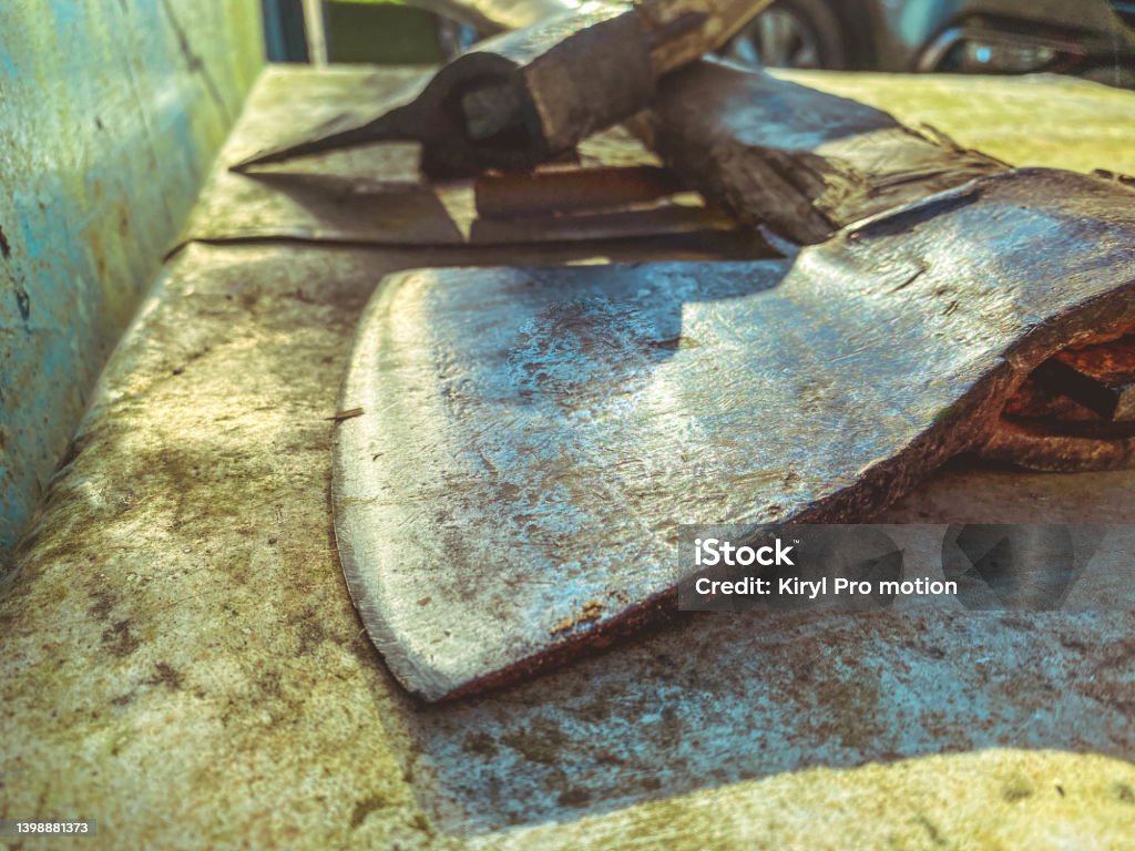 the ax lies on a metal bench. a tool for cutting wood, building a house, working with wood. metal ax with handle made of natural material the ax lies on a metal bench. a tool for cutting wood, building a house, working with wood. metal ax with handle made of natural material. Axe Stock Photo