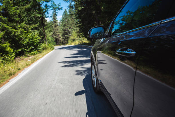 istock Driving car along the highway through pine forests at sunny day 1398883746