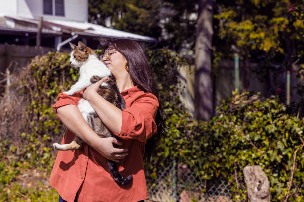 istock Woman holding her cat while walking outdoors on a sunny spring day. 1398885890