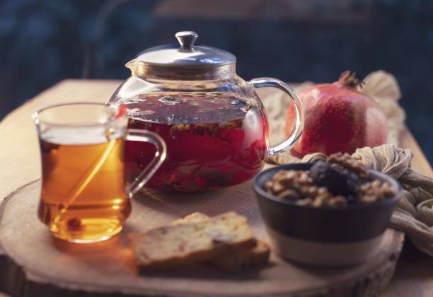 istock Morning breakfast with herbal tea, walnut, prune, pomegranate on wooden table. 1398887181