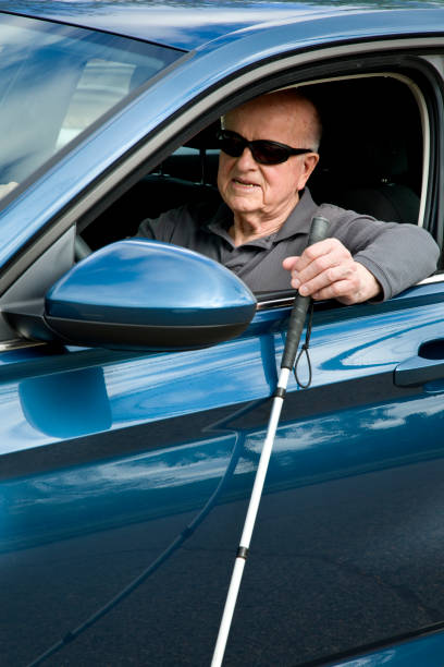 istock Blind man attempting to drive with blind persons cane 1398888666