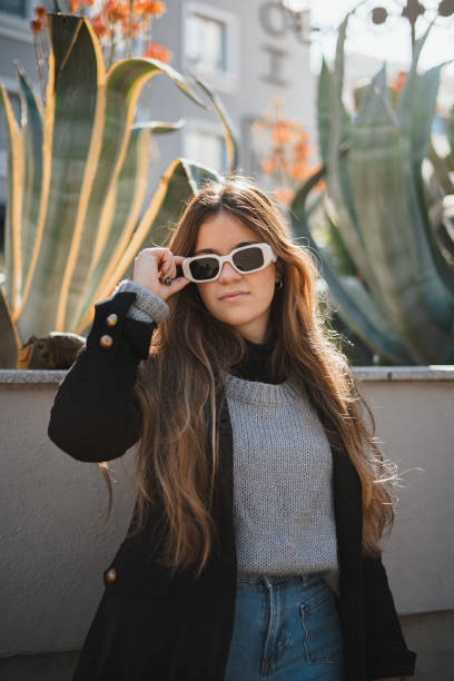 istock Young woman wearing sunglasses is posing 1398892225