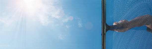 istock window cleaner cleaning window with squeegee and wiper on a sunny day 1398893086