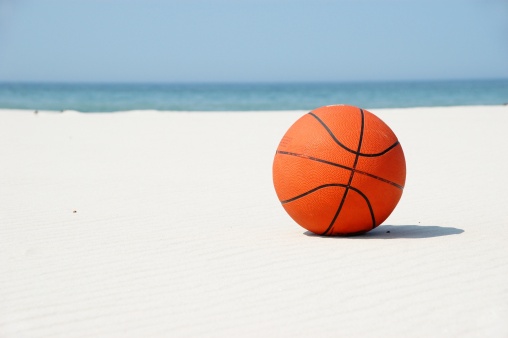 A basketball on a sandy beach. Time for retirement? I wouldn't say. Just preparing for the next game!