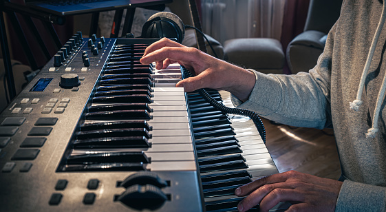 A man composer, producer, arranger, songwriter, musician hands arranging music on a computer at home studio, music production concept.