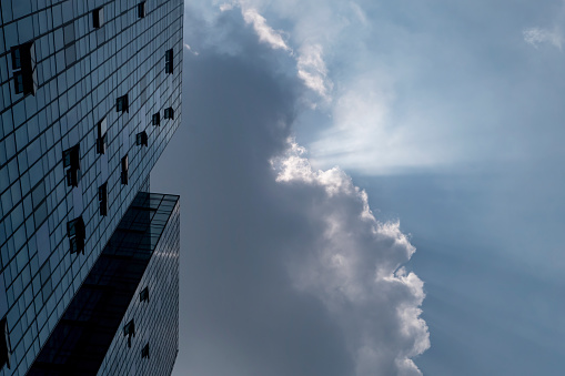 Facade of modern building under cumulonimbus clouds