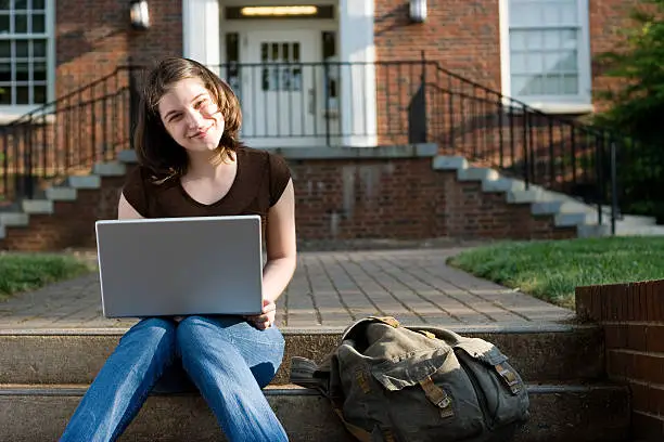Photo of Beautiful brunette private college student with laptop