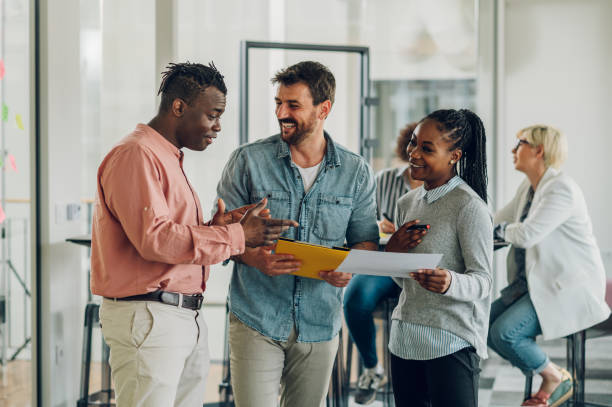 istock Multiracial business colleagues discussing about documents in the office 1398900799