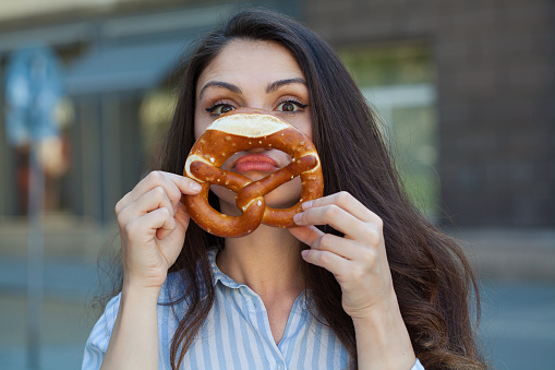 Young woman eating a pretzel