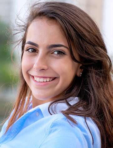 Smiling Hispanic female teenage girl posing looking at the camera